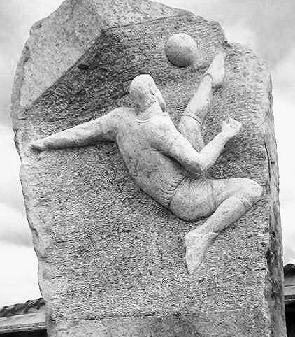 Gigi Riva nel suo momento glorioso: la storica rovesciata raffigurata in una roccia
