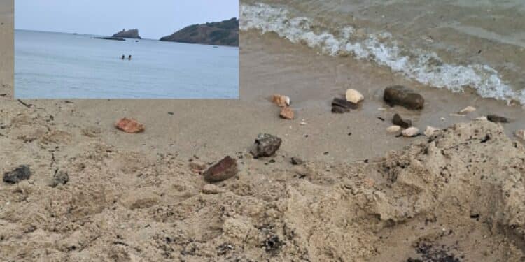 Pula, sassi spaccati in spiaggia da due bambini sotto gli occhi divertiti dei genitori