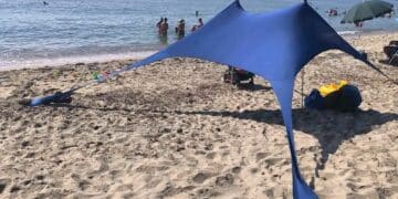 Nora, il maxi telo in spiaggia divide i bagnanti: “Sono accampamenti abusivi”. Ma c’è chi replica: “Lasciateci vivere il mare in libertà”